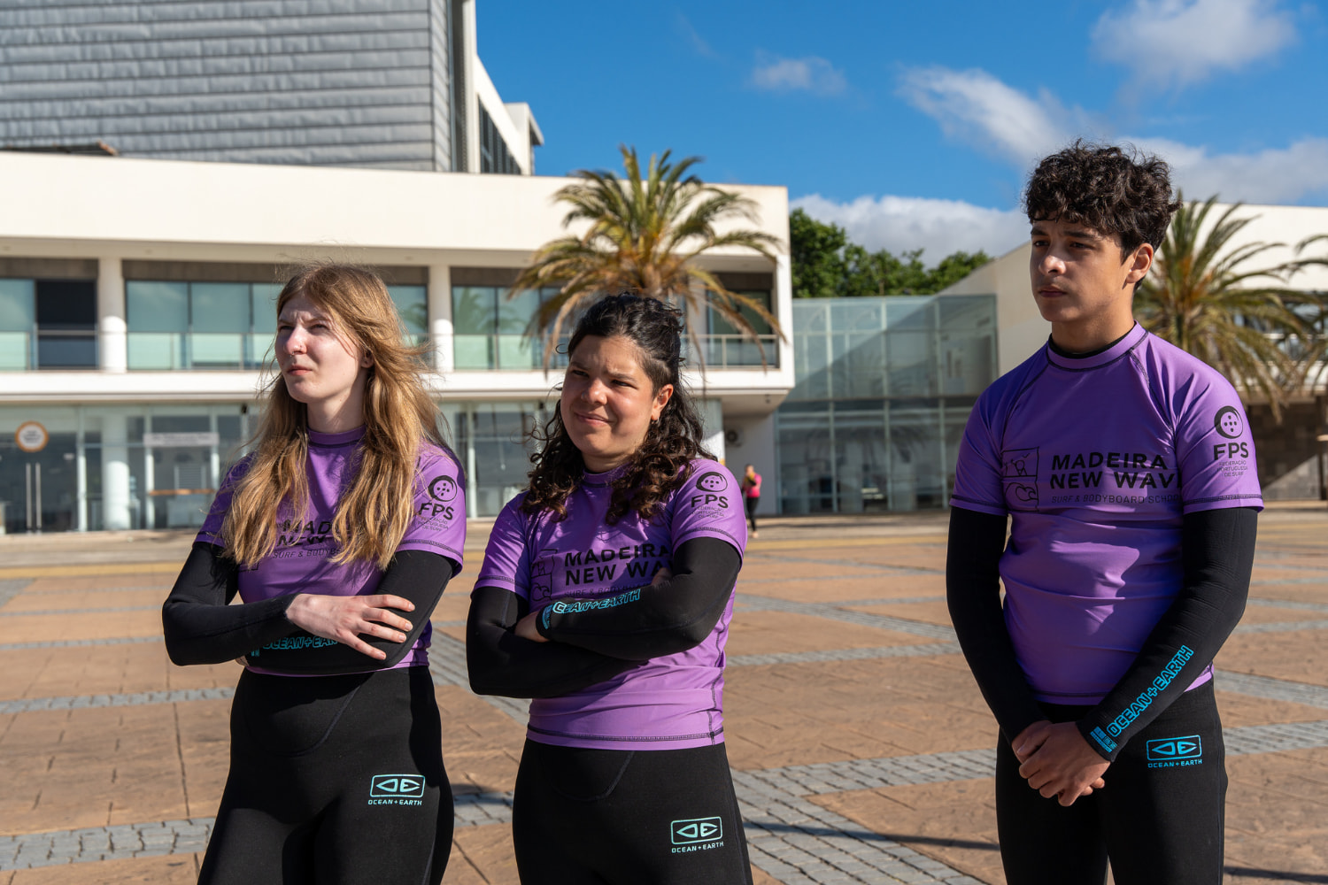 A group of friends paying attention to the surf instructor before their group surf lessons in madeira