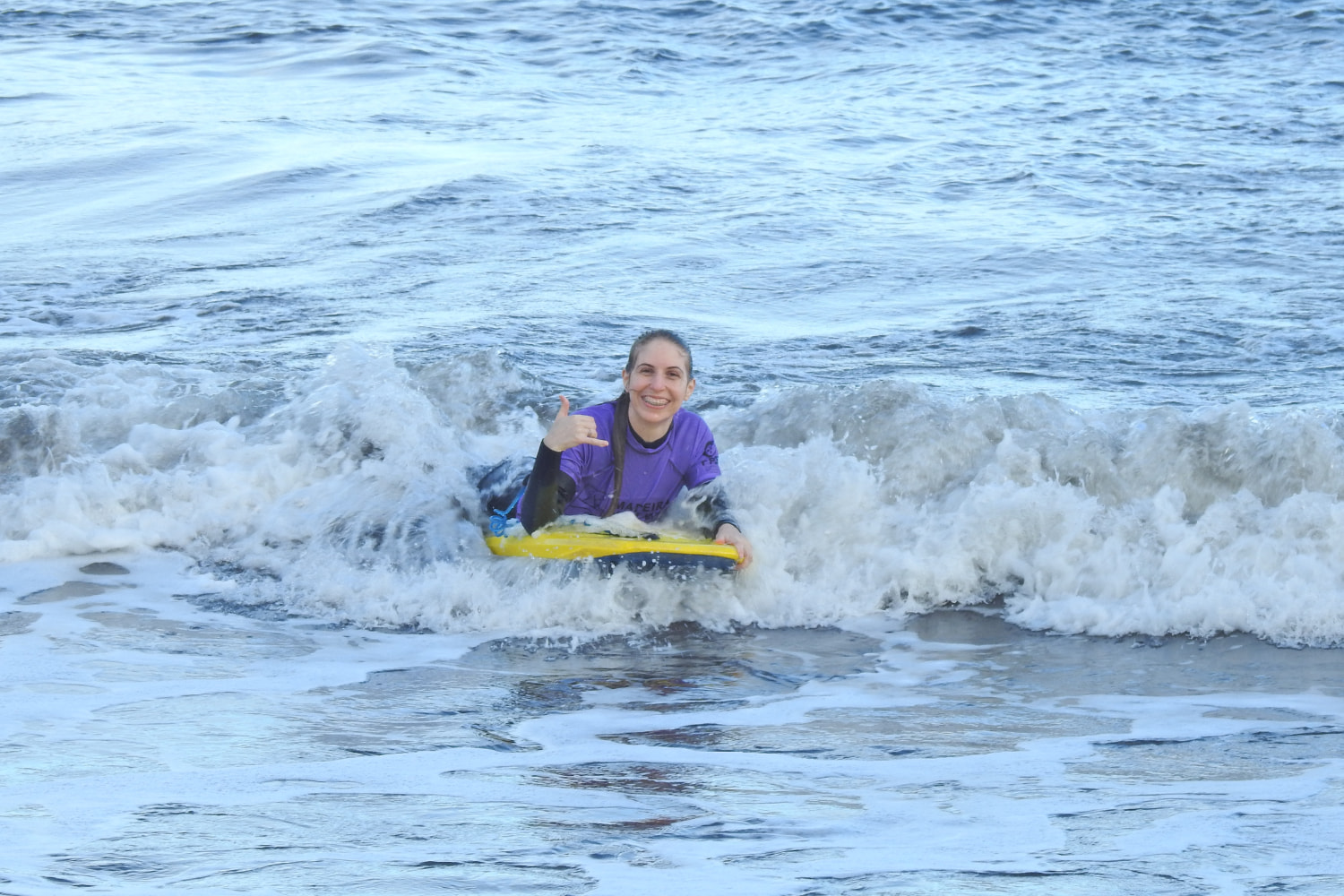 Happy female doing a group bodyboard lesson in madeira