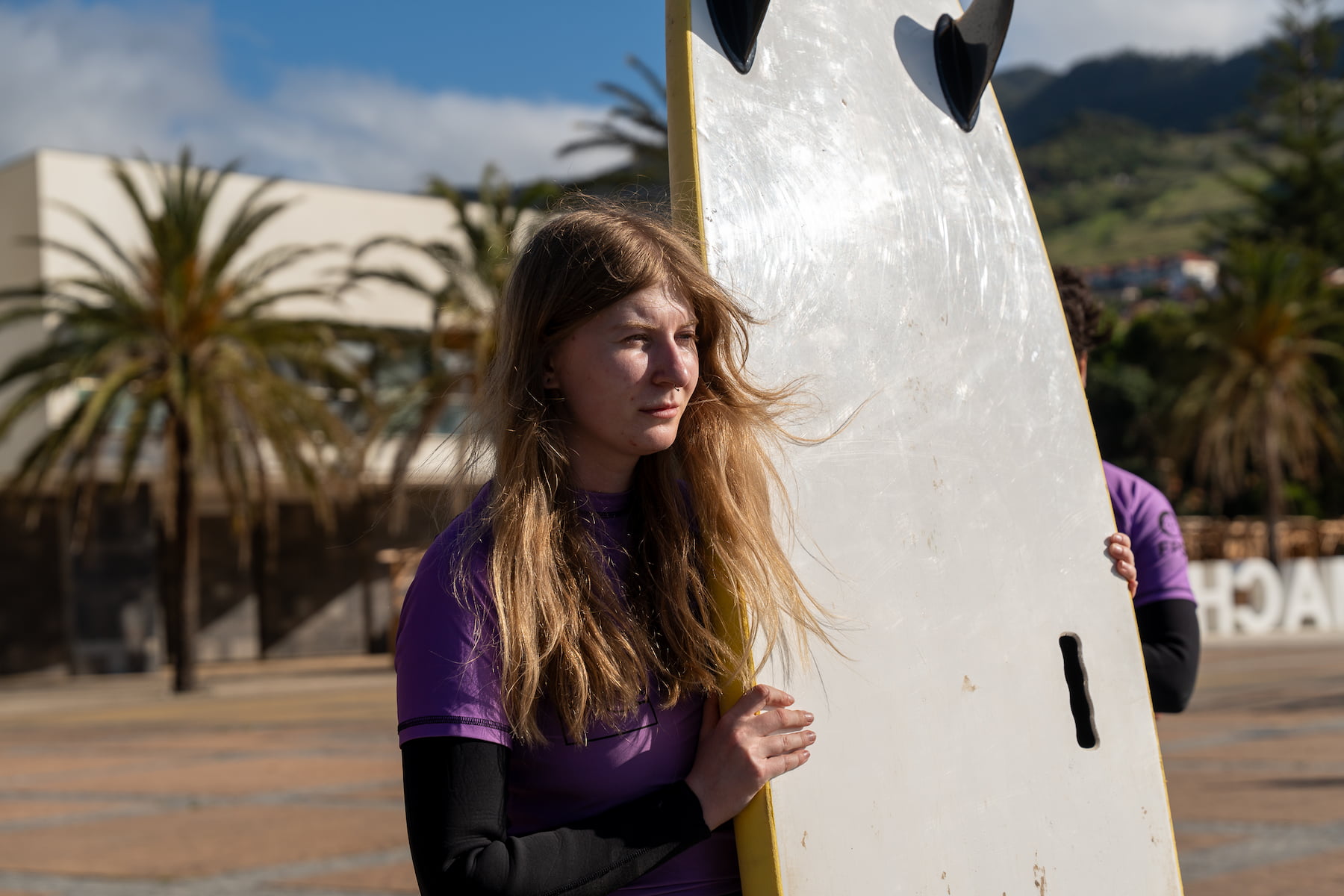 Female surfer with her rented surfboard in madeira, machico