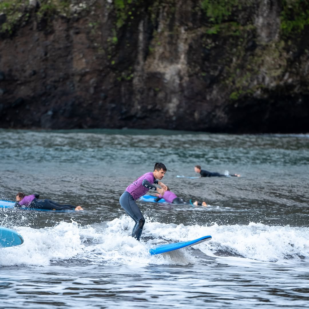 Surfer riding a wave while doing a surf lesson in seixal