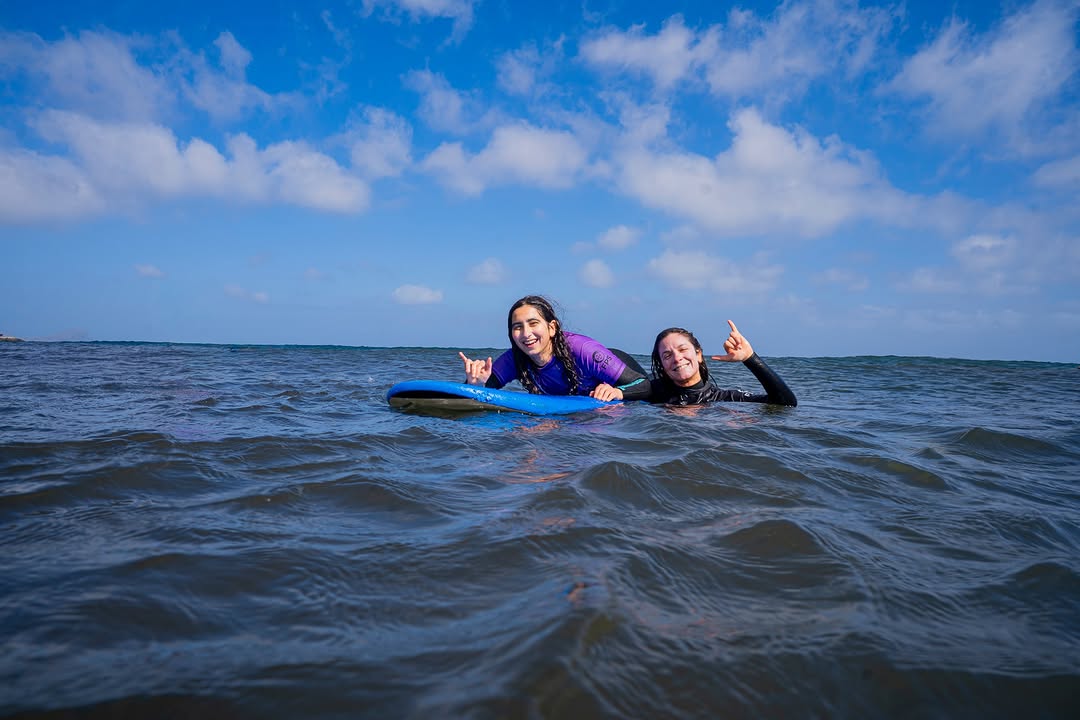 Female surfer with her instructor doing a private surf lesson in Porto da Cruz