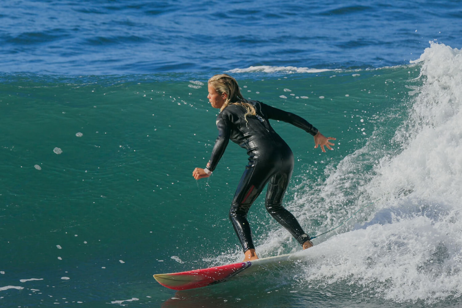 Experienced surfer riding a wave in a sunny day while using a rented surfboard in madeira